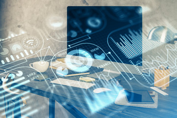 Computer on desktop in office with technology theme hologram. Multi exposure. Tech concept.