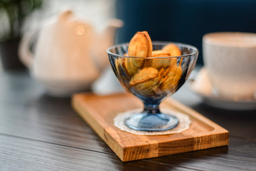 Russian walnut cookies stuffed with condensed milk in glass bowl in a restaurant with blurred background.