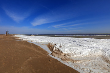 Watchtower on the sea, snow in the blue sky