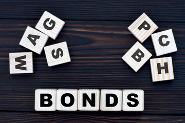 concept of the word bonds on cubes on a dark wooden background