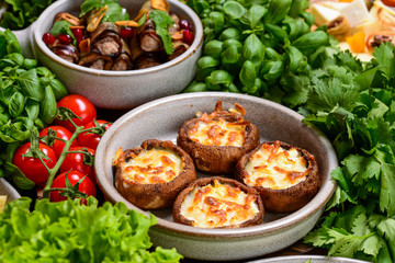 Georgian cuisine. Stuffed shampignon mushrooms with suluguni cheese baked in ketsi pan with greens and vegetables