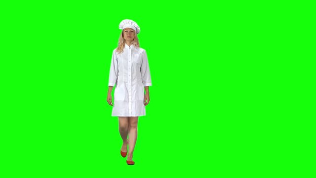 Blonde cook chef in white uniform and hat going against a green screen.