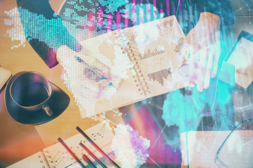 Obraz premium Multi exposure of hands making notes with forex chart huds. Stock market concept.