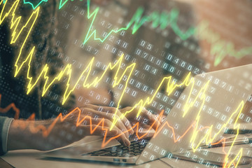 Fototapeta premium Double exposure of market chart with man working on computer on background. Concept of financial analysis.