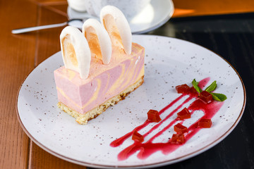 Ripe sea buckthorn mousse dessert with caramel biscuit served on a white plate