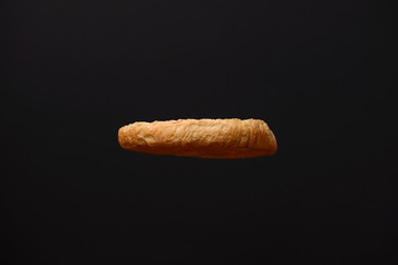 Fresh burger bun with sesame seeds on top isolated on black background. Copy space. Ingridients for making a hamburger.