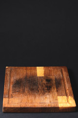 Kitchen wooden cutting board isolated on black background, food photography concept.