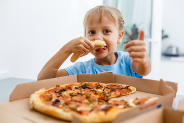 little girl eating pizza at home