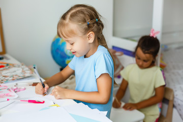 education, creation and school concept - smiling little student girl drawing and daydreaming at school