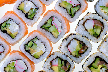 Sushi and rolls pattern background. Japanese cuisine, set of sushi rolls isolated on white.