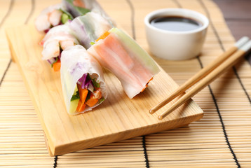 Delicious rolls wrapped in rice paper served on table