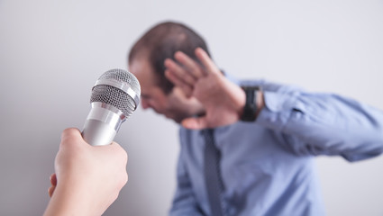 Hand holding microphone. Man refusing interview
