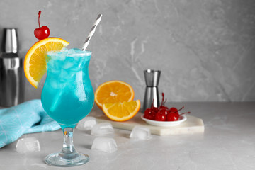Tasty Blue Lagoon cocktail on light grey marble table. Space for text