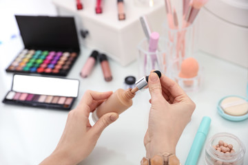 Woman applying makeup at dressing table, closeup