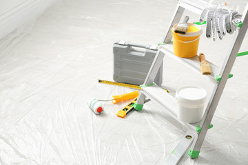 Stepladder and different tools in room, space for text. Interior renovation