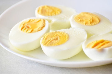 Boiled egg on a white plate. Selective focus at the front piece of egg and leave the back and another part of the photo blurry. Soft focus.