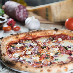 Pizza with meat, basil and cheese on plate