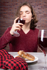 Young attractive student drinks red wine.