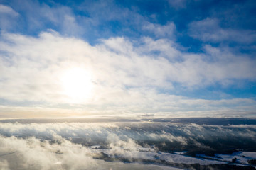 Fototapeta premium Aerial view clouds over forest. Aerial view of forest and clouds. Aerial drone view flying over the forest. Aerial top view cloudscape. Texture of clouds