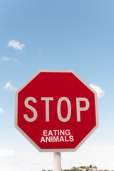 Traffic Stop sign altered, presumably by a vegan or vegetarian, with a sticker to read 
