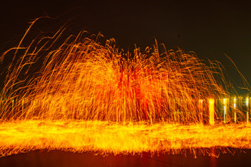 Chinese craftsmen spin hot iron melt at high speed, performing in the darkness, which is a traditional cultural heritage