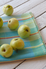 Fresh, ripe Apple harvest. Nature theme with green apples in a white basket on a wooden background. The concept of the nature of the fetus. Top view with space for text