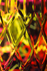 Abstract background of a bright colors through a diamond pattern lead crystal glass vase 