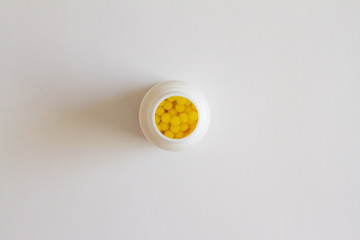 Yellow round tablets or vitamins in a white bubble, on a white background. Concept of medicine. Alternative homeopathy. Flatley. The view from the top. copyright for text.
