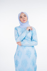 Beautiful Muslim female model wearing pastel blue modern kurung with hijab, a urban lifestyle apparel for Muslim women isolated on white background. Beauty and hijab fashion concept. Half length