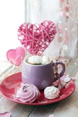 Fototapeta na wymiar Cup of coffee with meringues and marshmallows, hearts, illumination on a wooden windowsill, home comfort, St. Valentine's Day