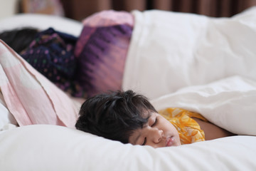 baby child sleeping with mother on bed