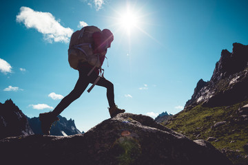 Successful woman hiker hiking in sunrise mountains