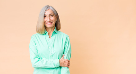 middle age cool woman laughing shyly and cheerfully, with a friendly and positive but insecure attitude