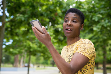 Doubting beautiful woman recording audio message. Thoughtful brunette holding smartphone and talking. Voice recognition, technology concept