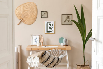 Design scandinavian interior of home office space with a lot of mock up photo frames, wooden desk, white armchair, plants, office and personal accessories. Stylish neutral home staging. Template.