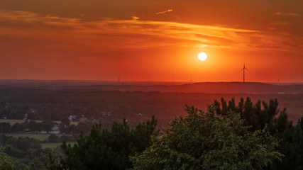 The setting sun and some wind turbines in the Ruhr Area, seen from the Halde Haniel, Bottrop, North...