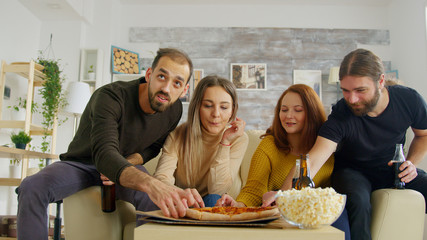 Close friends watches tv in living room