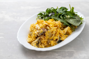 cod fish with mashed eggs on the dish on ceramic background