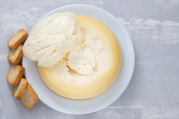 soft portuguese cheese with toasts on white plate on ceramic background