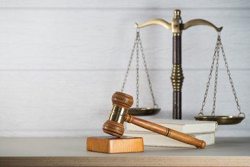 Law theme, mallet of the judge, white wooden background, books