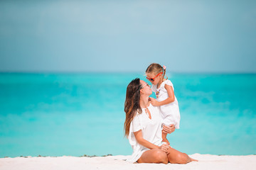 Beautiful mother and daughter at the beach enjoying summer vacation.