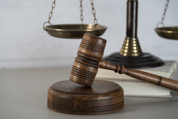 Law theme, mallet of the judge, white wooden background, books