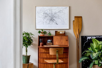 Stylish and vintage interior design of living room with wooden retro commode, plants, ships,...