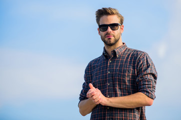 Man eyewear model outdoors blue sky background. Handsome guy wear sunglasses. Hipster man in trendy...
