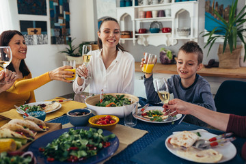 caucasian mixed aged family and friends having vegetarian dinner party at home