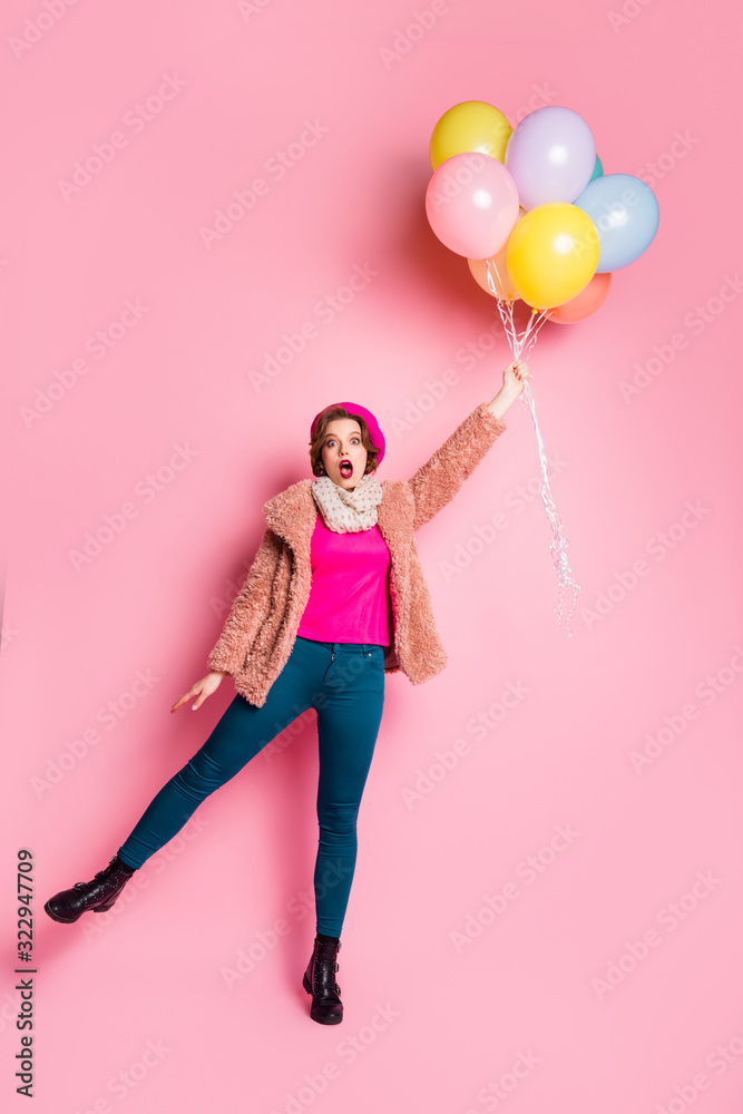 Sticker Full body vertical photo of funny pretty lady hold many colorful air balloons flying up air open mouth wear modern fur coat scarf beret cap pants shoes isolated pink color background