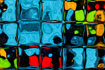 Abstract background of a colorful image distorted through a glass block wall