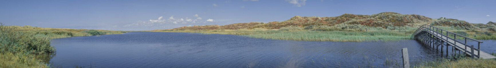 Dünen und See mit Holzbrücke in Dänemark Panorama.