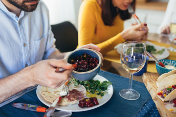 close up of caucasian mixed aged family and friends having vegetarian dinner party at home