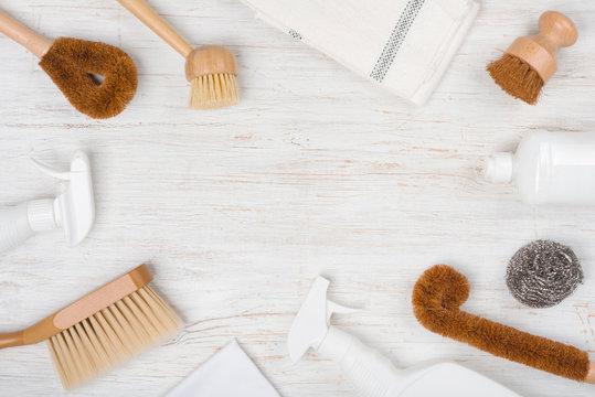 Eco natural cleaning brushes, cloth and detergent on wooden background